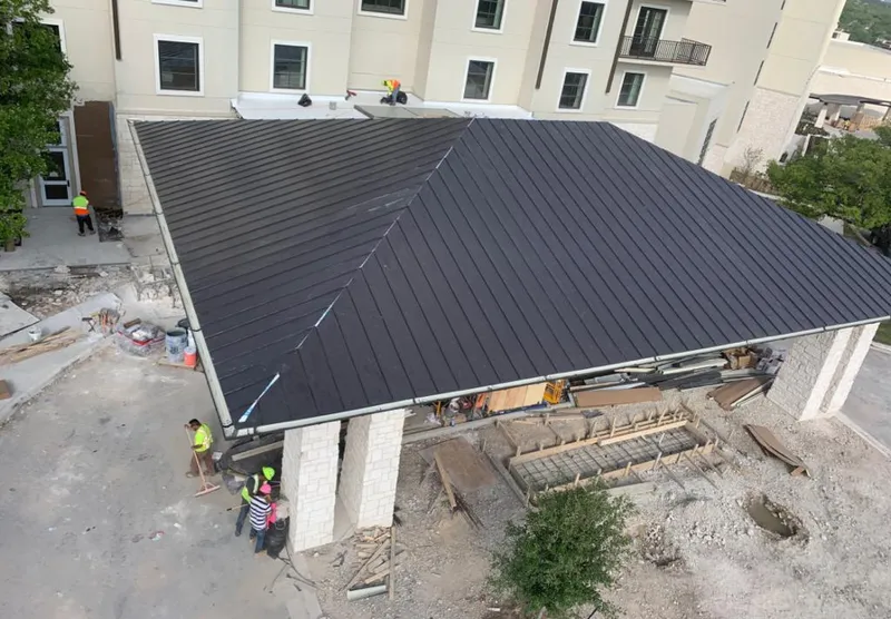 Metal roofing installation team working on a commercial building in Ewa Villages